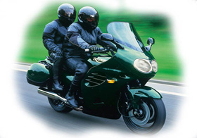 two people riding a green motorcycle